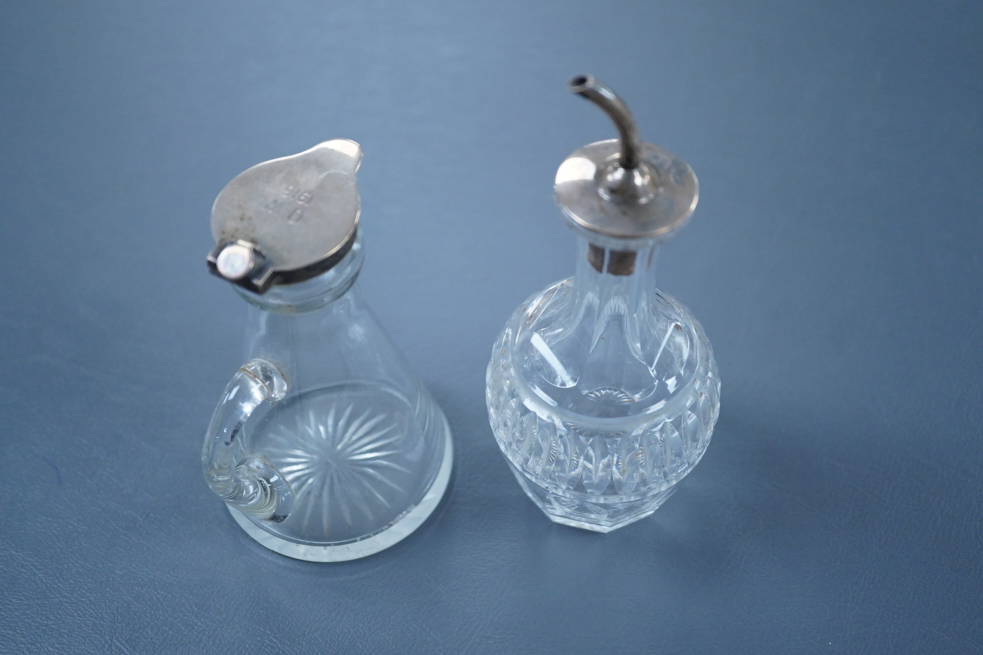 A George V silver mounted glass whisky noggin, indistinct maker's mark, Birmingham, 1913, with later engraved inscription, height 10.5cm, together with a later silver mounted cut glass oil or vinegar bottle.
